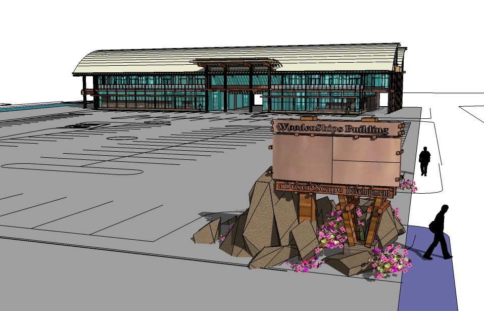 Wooden Ships Building, a modern structure with a large parking lot, features a prominent sign on a rocky base adorned with flowers.
