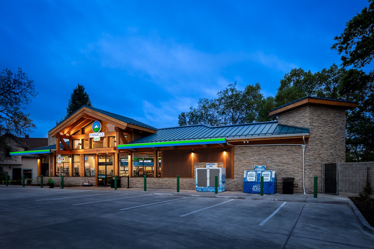 Pinnacle 365 store exterior at twilight, showcasing its wooden architecture and bright signage, highlighting its welcoming atmosphere for visitors.
